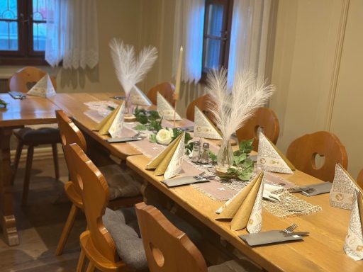 Rustikal gedeckter Tisch mit dekorativen Servietten und Pflanzenarrangements.
